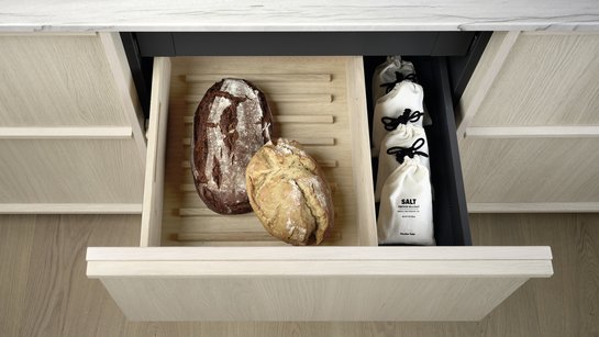 Geöffnete Schublade in Küchenzeile in heller eiche mit zwei Brotlaiben darin