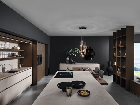 Inselküche in Betonoptik kombiniert mit dunklem Holzfurnier