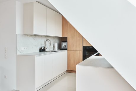 Weiße Küche aus Küchenzeilen mit holzfarbigem Hochschrank